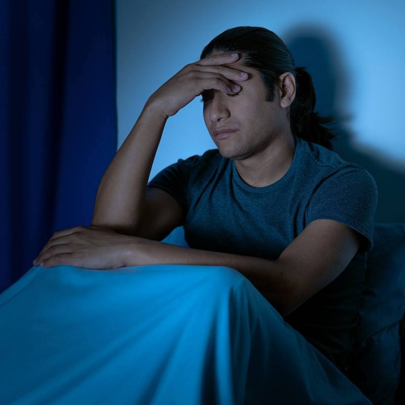 Tired Man with Hand on Head Suffering with Insomnia