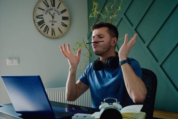 Man Acting Silly and Procrastinating at Work Desk Bored