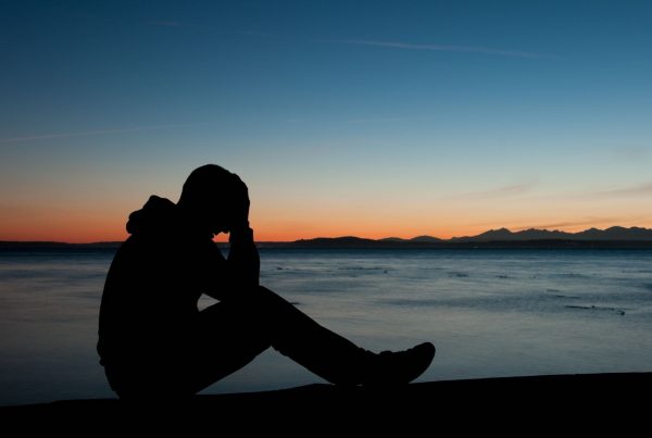 Man with Hands on Head Frustrated Sitting on a Mountain with View