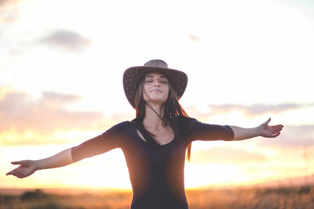 Beautiful Woman with Arms Wide Open Happy with Sunset in the Background