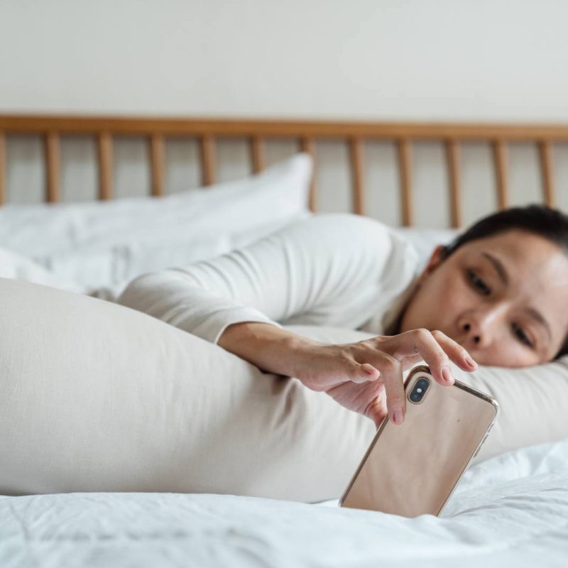 Woman Lying on Bed with Phone Being Lazy