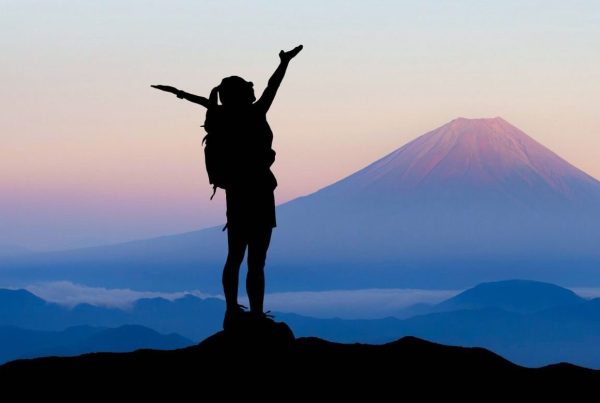 Woman Standing on Top of Mountain with Arms Open Wide Success Challenge