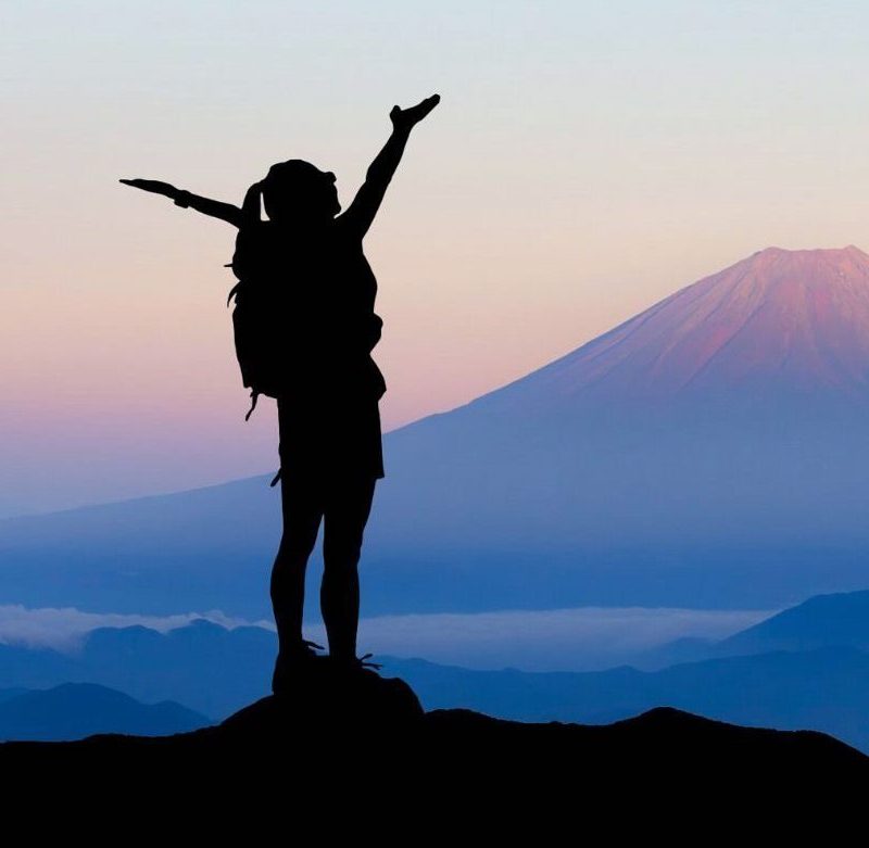 Woman Standing on Top of Mountain with Arms Open Wide Success Challenge