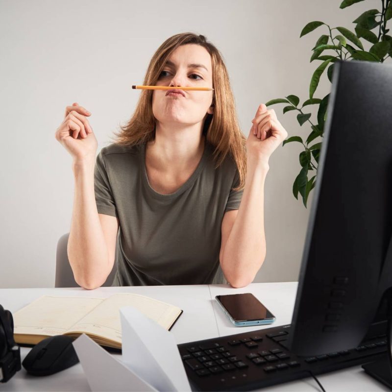 Woman Being Distracted Playing with Pencil on Her Mouth in Office