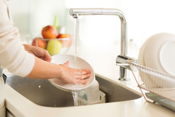 Woman Washing Dishes in Sink