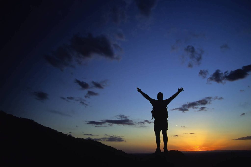 Silhouette of a Man with Hands in the Air Motivated with Sunset View