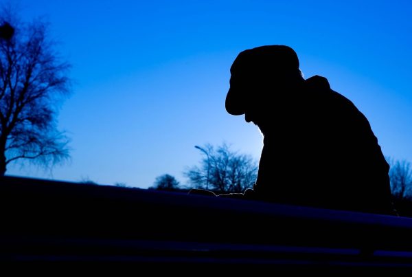 Silhouette of Depressed Man with Trees in Background