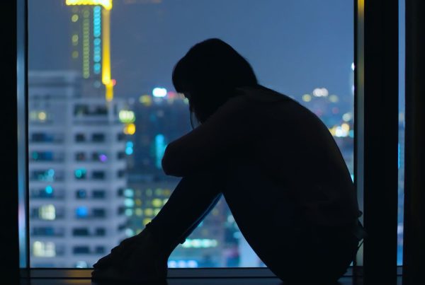 Woman Sitting on Windowsill Depressed and Sad with City View