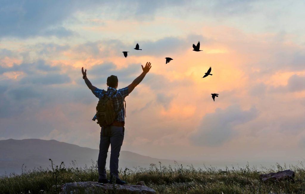 Man with Hands up in the Air Free with Birds Flyinf