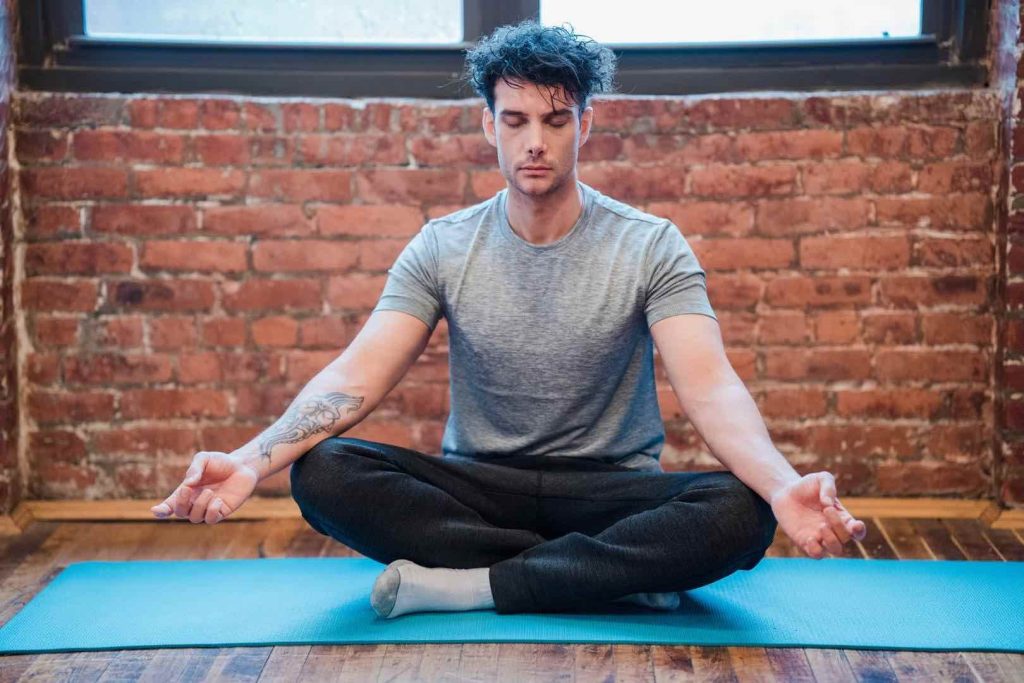 Man Meditating on Blue Yoga Mat