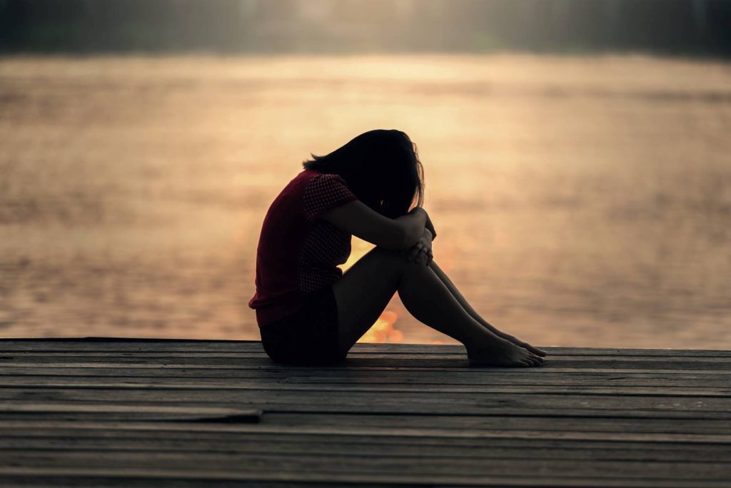 Sad Girl Sitting on a Pier Depressed