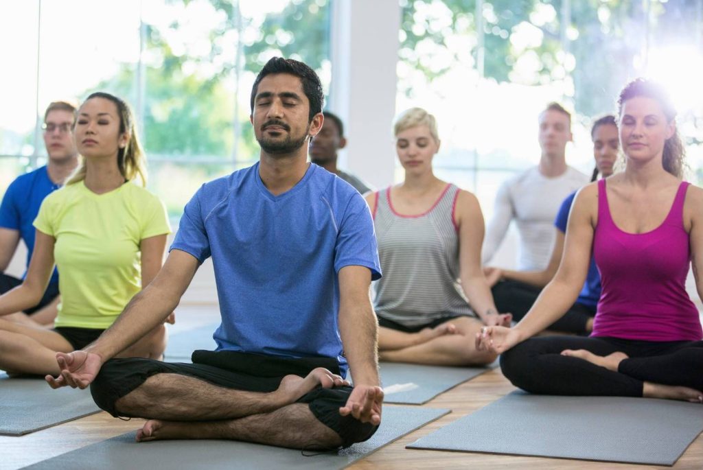 Diverse Group of People Meditating in a Room Together