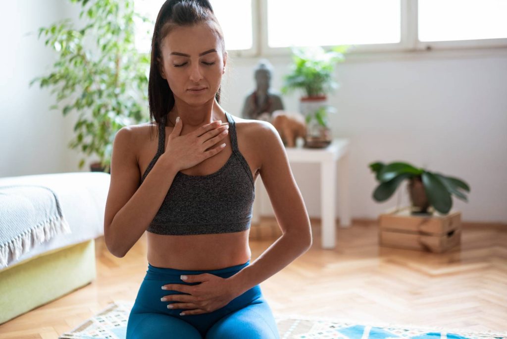 Woman Meditating with Hand on Chest and Abdomen